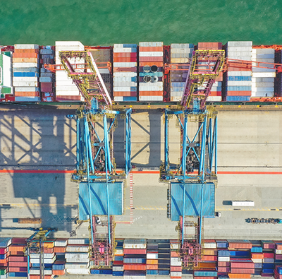 Bild uppifrån på lastfartyg med containrar.